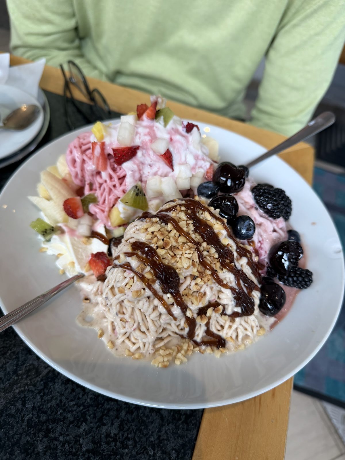 Großer Fruchtbecher mit Eis und frischem Obst auf einem Tisch