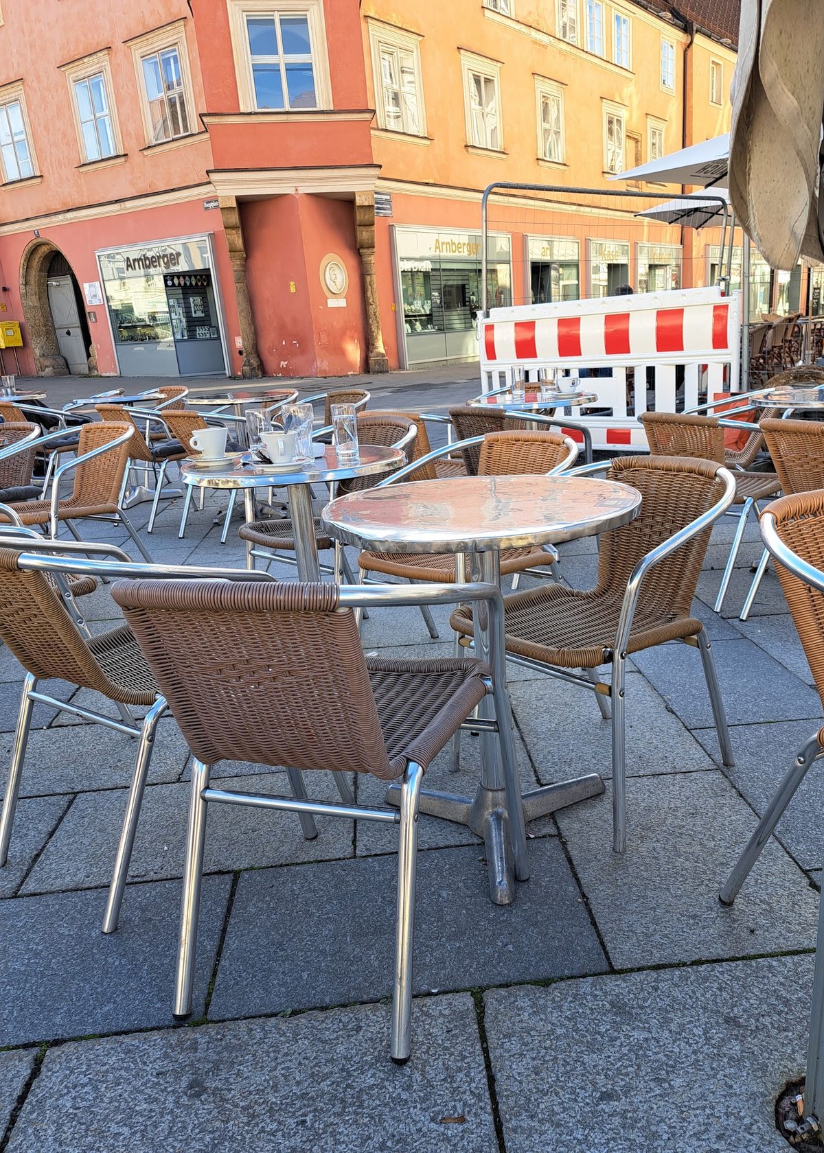 Gedeckte Tische und Sessel des Café Martini auf dem Hauptplatz